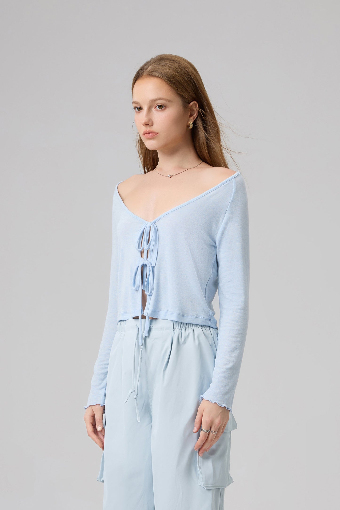 Woman wearing a light blue outfit on a plain background