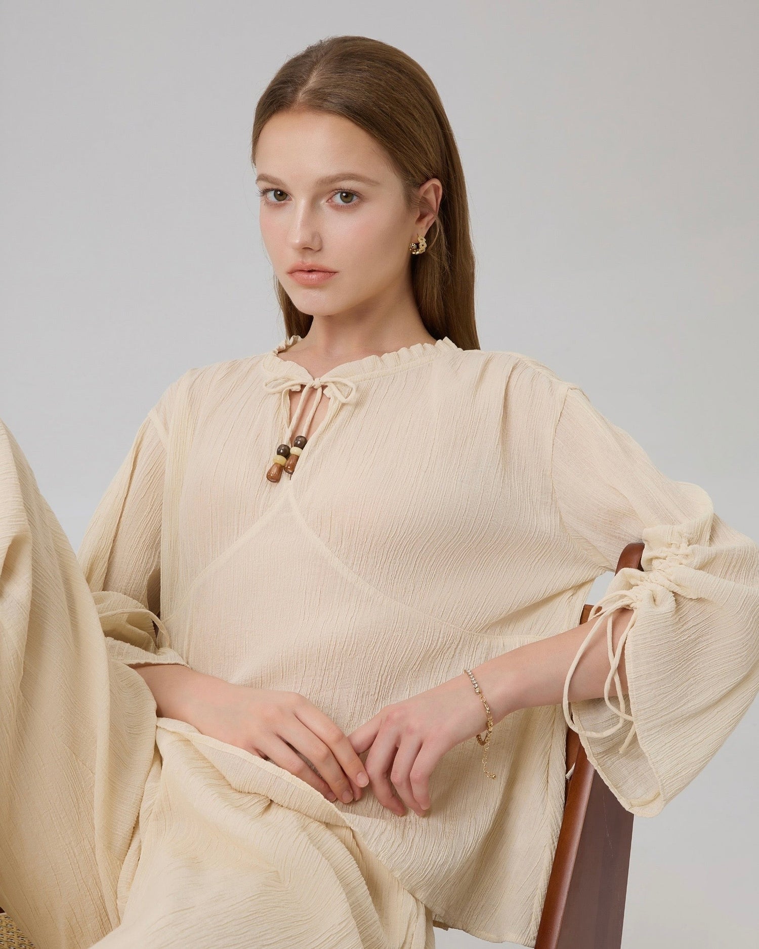 Close-up of tie neckline and adjustable drawstring sleeves with matching beads on Lethe Drift Drawstring Sleeve Blouse