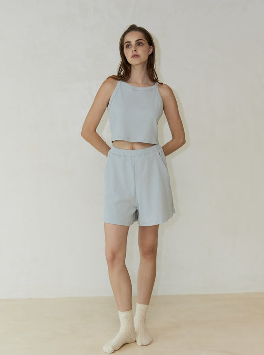 Model wearing Lethe Summer Knit A-Shape Shorts in Icy Blue paired with matching halter crop top