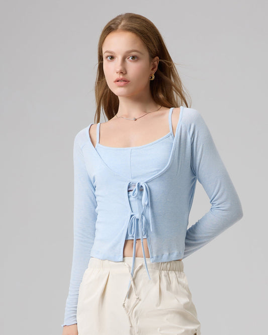Woman wearing a light blue top and beige pants on a gray background